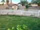 Lush backyard with green lawn, a white picket fence and mature palm trees at 171 W Hawaii Dr, Casa Grande, AZ 85122