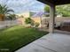 A well-manicured backyard with green grass, an umbrella, and a covered patio invites relaxation and outdoor enjoyment at 171 W Hawaii Dr, Casa Grande, AZ 85122