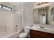 Bathroom featuring vanity with wood cabinets and a shower/tub with white tile surround at 17878 N 114Th Ln, Surprise, AZ 85378
