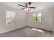 Bedroom featuring carpet, ceiling fan, and dual windows for ample natural light at 17878 N 114Th Ln, Surprise, AZ 85378