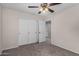 Spacious bedroom with carpet, ceiling fan and closet with double doors at 17878 N 114Th Ln, Surprise, AZ 85378