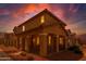Inviting two-story home featuring a covered porch with stylish columns during a colorful dusk at 17878 N 114Th Ln, Surprise, AZ 85378