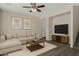 Cozy living room with L shaped couch, modern decor, ceiling fan, and grey wood floors at 17878 N 114Th Ln, Surprise, AZ 85378