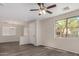 Bright living room features gray wood floors, a ceiling fan, and natural light at 17878 N 114Th Ln, Surprise, AZ 85378