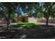 Beautiful backyard with lush green lawn, covered patio, mature trees and low maintenance rock landscaping at 18116 N Catherine Dr, Surprise, AZ 85374