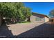 Lovely backyard features desert landscaping, grass, a large shade tree, and a block fence at 18116 N Catherine Dr, Surprise, AZ 85374