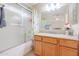 Lovely bathroom features a shower-tub, wood vanity with countertop, and a large mirror at 18116 N Catherine Dr, Surprise, AZ 85374
