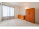Bedroom with carpet, bright window, and wooden closet and dresser at 18116 N Catherine Dr, Surprise, AZ 85374