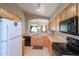 Kitchen with white refrigerator and black appliances, with a view to the dining room at 18116 N Catherine Dr, Surprise, AZ 85374