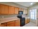 Well-lit kitchen with light wood cabinets, black appliances, and neutral countertops at 18116 N Catherine Dr, Surprise, AZ 85374