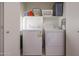 The laundry room is equipped with a standard washer, dryer, and shelf space for convenience at 18116 N Catherine Dr, Surprise, AZ 85374