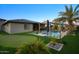 Expansive backyard with a sparkling pool, verdant landscaping, putting green, and covered patio for serene outdoor enjoyment at 18175 W Highland Ave, Goodyear, AZ 85395