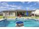 Lush backyard featuring a stunning pool, manicured landscaping, covered patio, and outdoor seating perfect for entertaining at 18175 W Highland Ave, Goodyear, AZ 85395