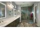 Bright bathroom featuring double sinks, framed mirrors, and a glass shower at 18175 W Highland Ave, Goodyear, AZ 85395
