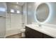 Bright bathroom features a shower-tub combo, modern vanity with a circular LED mirror, and sleek fixtures at 18175 W Highland Ave, Goodyear, AZ 85395