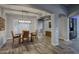 Dining room features hardwood floors, a farmhouse table, a modern chandelier, and ample natural light at 18175 W Highland Ave, Goodyear, AZ 85395