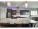 Island kitchen boasts granite countertops, a modern hood, stainless steel appliances, and pendant lighting at 18175 W Highland Ave, Goodyear, AZ 85395