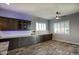 Spacious kitchen with granite counters, dark wood cabinets, and wood-look tile flooring at 18175 W Highland Ave, Goodyear, AZ 85395