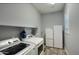 Spacious laundry room with washer, dryer, sink, and mini fridge at 18175 W Highland Ave, Goodyear, AZ 85395
