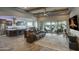 Spacious living room with wood beam ceiling, a ceiling fan, and sliding glass doors to the backyard at 18175 W Highland Ave, Goodyear, AZ 85395