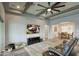 Open concept living room with wood beam ceiling, ceiling fan, media center, and dining room views at 18175 W Highland Ave, Goodyear, AZ 85395