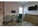 Bedroom converted into an office features wood-look tile flooring, desk, and closet at 18175 W Highland Ave, Goodyear, AZ 85395