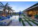 Inviting backyard patio with a sparkling pool, lush landscaping, and comfortable outdoor seating for relaxing and entertaining at 18175 W Highland Ave, Goodyear, AZ 85395