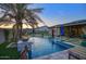 Beautiful pool with integrated fire bowls, travertine tile, and an outdoor living area at 18175 W Highland Ave, Goodyear, AZ 85395
