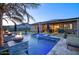 Beautiful pool with integrated fire bowls, travertine tile, and an outdoor living area at 18175 W Highland Ave, Goodyear, AZ 85395