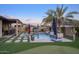 Stunning backyard pool with fire bowls, lush landscaping, and outdoor living spaces creates a luxurious entertainment area at 18175 W Highland Ave, Goodyear, AZ 85395