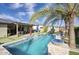 Backyard pool featuring pristine water, stone accents, mature palms, and a covered patio for luxurious outdoor living at 18175 W Highland Ave, Goodyear, AZ 85395