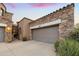 Attached two-car garage with desert landscaping and a desert-style home at 19550 N Grayhawk Dr # 1117, Scottsdale, AZ 85255