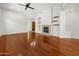 Spacious living room featuring a cozy fireplace, custom shelving, and hardwood floors at 19550 N Grayhawk Dr # 1117, Scottsdale, AZ 85255
