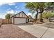 Home's exterior with gravel landscaping, two-car garage, and mature trees at 20626 N 5Th Ave, Phoenix, AZ 85027