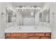 Bathroom with double sinks, vanity with a wooden cabinet, and a large mirror with light fixtures at 21031 E Creekside Dr, Queen Creek, AZ 85142