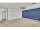 Spacious bedroom with neutral carpet, a blue accent wall, and an open doorway at 21031 E Creekside Dr, Queen Creek, AZ 85142
