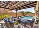 Inviting outdoor patio area with comfortable seating and a view of the pool and landscaped backyard at 21031 E Creekside Dr, Queen Creek, AZ 85142