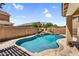 Inviting backyard pool surrounded by a stone patio and privacy fencing at 21031 E Creekside Dr, Queen Creek, AZ 85142