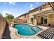 Beautiful backyard pool with rock features and lush landscaping for relaxation at 21031 E Creekside Dr, Queen Creek, AZ 85142