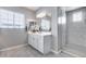 Bright, well-maintained bathroom with a large mirror, modern shower, and white cabinets at 214 W Beverly Ln, Phoenix, AZ 85023