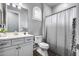 Cozy bathroom with wood floors, a white vanity, a toilet and a shower at 214 W Beverly Ln, Phoenix, AZ 85023