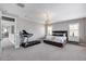 Large primary bedroom with a modern chandelier, exercise equipment and ensuite bathroom at 214 W Beverly Ln, Phoenix, AZ 85023