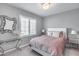 Cozy bedroom with a soft pink bedspread, elegant decor, and a sunlit window at 214 W Beverly Ln, Phoenix, AZ 85023