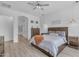 This is a bright bedroom with wood-look floors, ceiling fan, and en-suite bathroom at 22346 N 104Th Ln, Peoria, AZ 85383