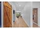 Long hallway featuring wood floors, a barn door, and views into the living room at 22346 N 104Th Ln, Peoria, AZ 85383