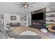 Modern living room featuring a stylish fireplace, large TV, comfortable seating, and bright, airy decor at 22346 N 104Th Ln, Peoria, AZ 85383