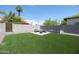 Backyard seating area with a fire pit, surrounded by artificial turf and a block fence at 2320 E Mulberry Dr, Phoenix, AZ 85016