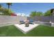 Outdoor seating area with a fire pit, surrounded by artificial turf and a block fence at 2320 E Mulberry Dr, Phoenix, AZ 85016