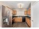 Kitchen with wood cabinets, tile flooring, stainless refrigerator and black appliances, and a window at 2893 E Cherry Hills Dr, Chandler, AZ 85249