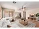 Staged living room with a white couch, neutral rug, ceiling fan, and view of the eat-in kitchen at 2893 E Cherry Hills Dr, Chandler, AZ 85249